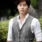 Young man wearing gray vest outdoors