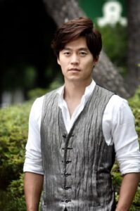 Young man wearing gray vest outdoors