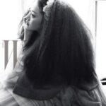 Woman with voluminous hair gazing out window