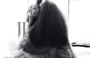 Woman with voluminous hair gazing out window