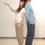Two people standing back-to-back, posing