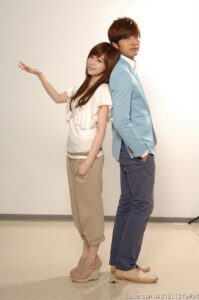 Two people standing back-to-back, posing
