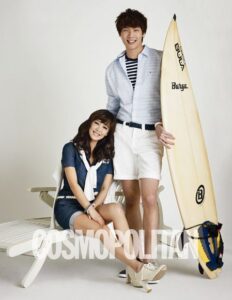 Smiling couple in summer outfits with surfboard