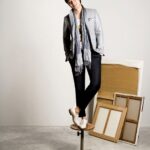 Man in blazer and scarf posing on stool