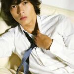 Young man in white shirt adjusting tie