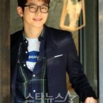 Smiling young man wearing glasses and blazer