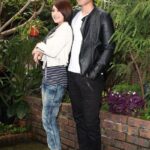 Young couple posing outdoors near lush plants