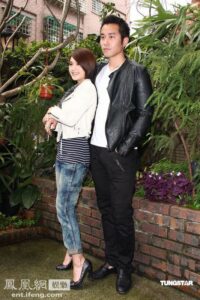 Young couple posing outdoors near lush plants