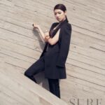 Fashion model in black suit against concrete wall