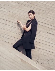 Fashion model in black suit against concrete wall