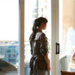Man and woman talking by apartment balcony door