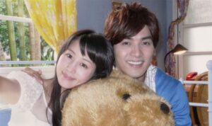 Smiling couple hugging large teddy bear