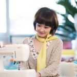 Young woman sewing at machine