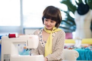 Young woman sewing at machine