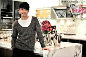 Smiling man leaning on marble kitchen counter