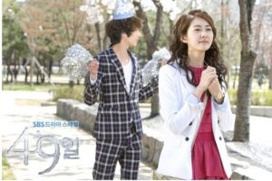 Woman clasping hands in park, man celebrating behind