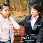 Two children on park bench, boy in suit