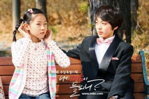 Two children on park bench, boy in suit