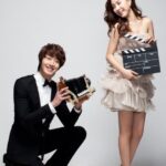 Smiling couple with vintage camera and clapperboard