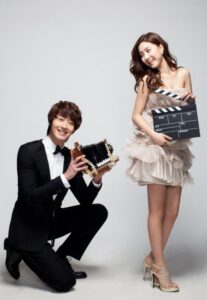 Smiling couple with vintage camera and clapperboard