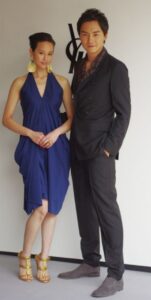 Stylish couple posing by designer logo