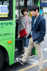 Young man and woman boarding green bus
