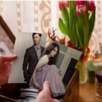 Hands holding photographs of man and woman