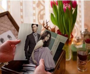 Hands holding photographs of man and woman