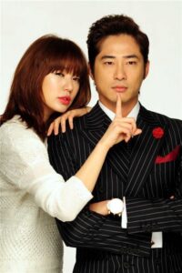 Woman leaning on suited man, finger to lips