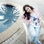 Smiling woman relaxing beside a swimming pool