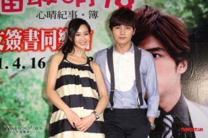 Two people posing at promotional poster