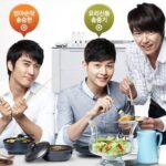 Three men preparing and serving salad