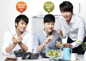 Three men preparing and serving salad