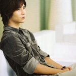 Young man sitting on couch, looking thoughtful