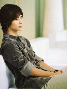 Young man sitting on couch, looking thoughtful