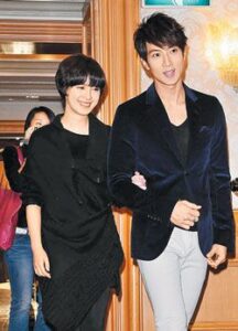 Smiling man and woman arm-in-arm indoors