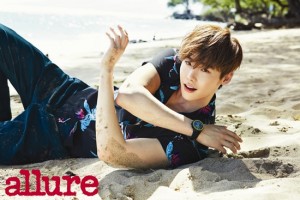 Man lounging on beach, wearing floral shirt.