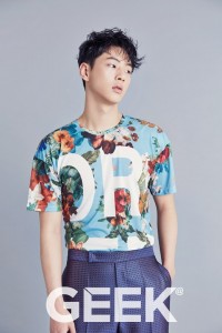 Young man in floral shirt posing thoughtfully.