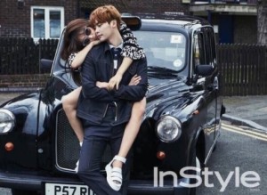 Couple posing playfully by a black taxi.