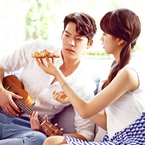 Couple sharing pizza while playing ukulele.