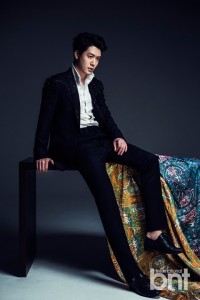Man in a stylish outfit sitting on a table.