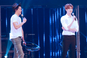 Two performers on stage with microphones.