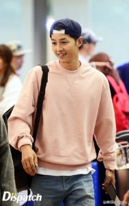 Smiling man in a pink sweatshirt and cap.