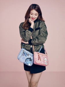 Woman holding two colorful handbags.