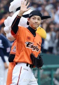 Person in baseball uniform waving at crowd.