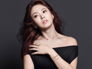 Woman in an elegant black outfit, showcasing jewelry.