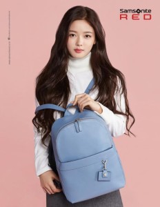 Young woman with a blue backpack, studio shot.