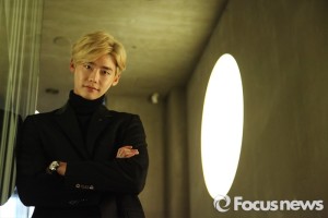 Man in black suit near circular light.