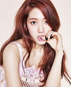 Young woman with long, wavy reddish hair.