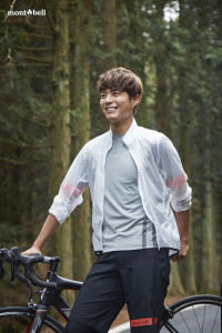 Smiling person in athletic clothing by bike.